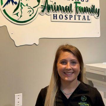 A staff member stands in front of the Billings Animal Family Hospital sign. 